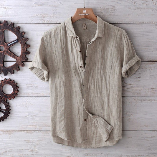Men's fashion solid color retro distressed beige linen shirt with rolled sleeves on wooden hanger against white wooden background