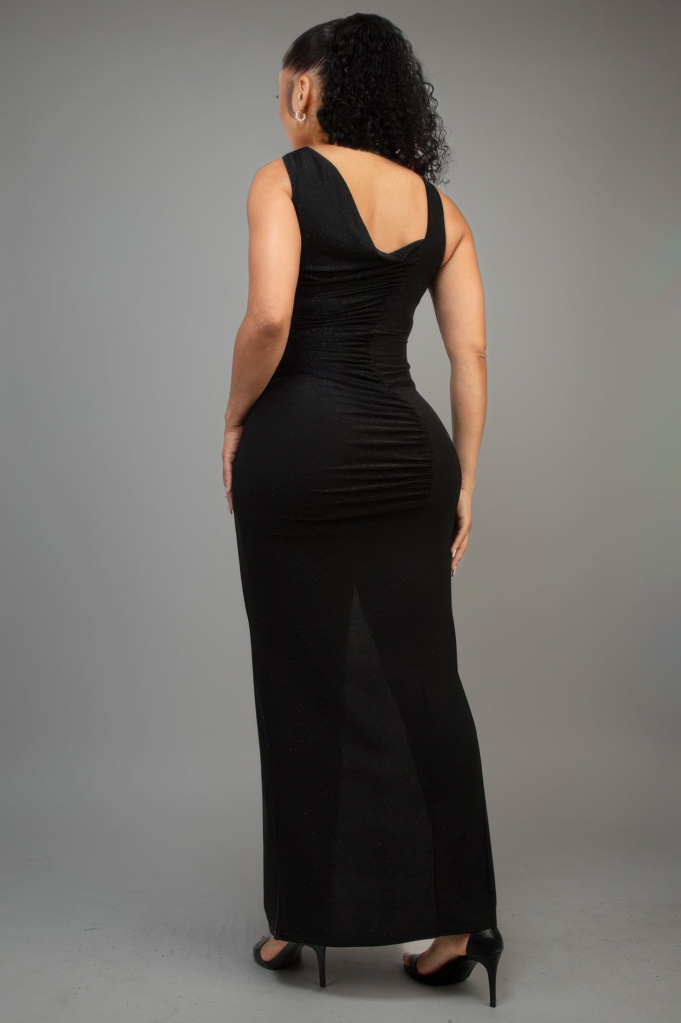 Black glitter slitted dress with one-shoulder design, back view.