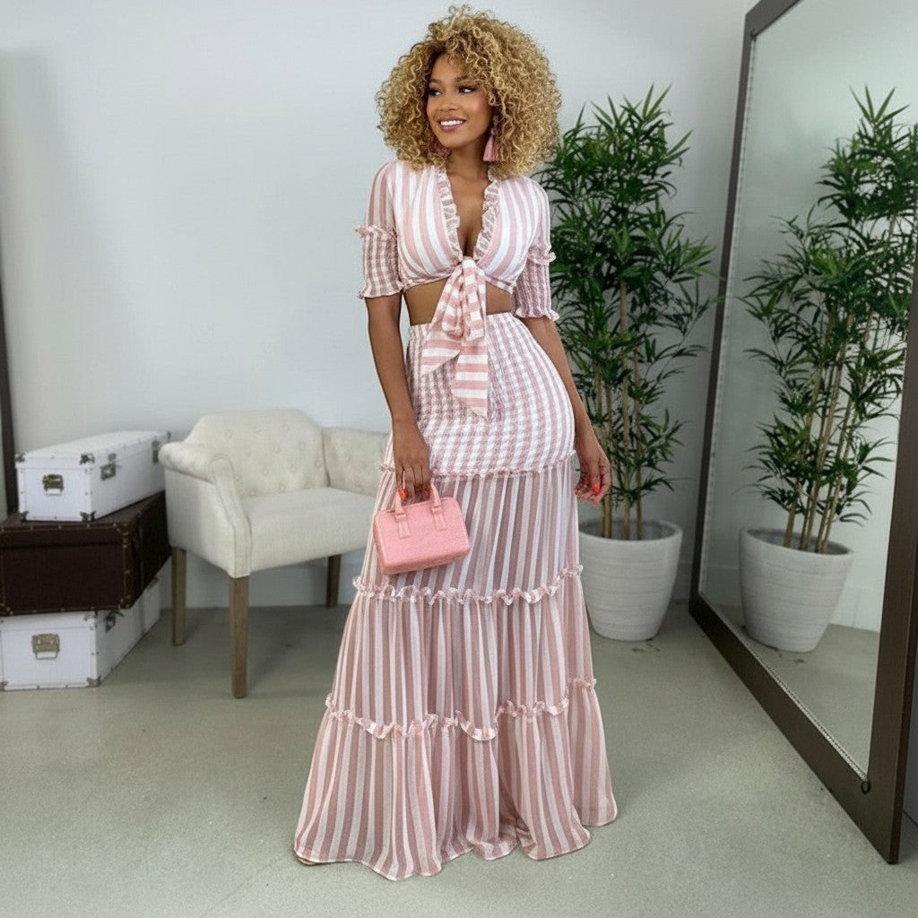 GIGI & POPO two-piece striped see-through dress with V-neck top and tiered maxi skirt on a model in a studio.
