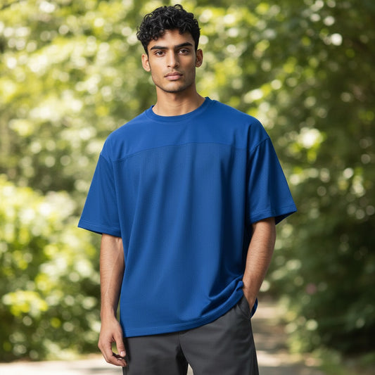 GIGI & POPO blue varsity football jersey with a silky stretch top and breathable mesh bottom on a male model.