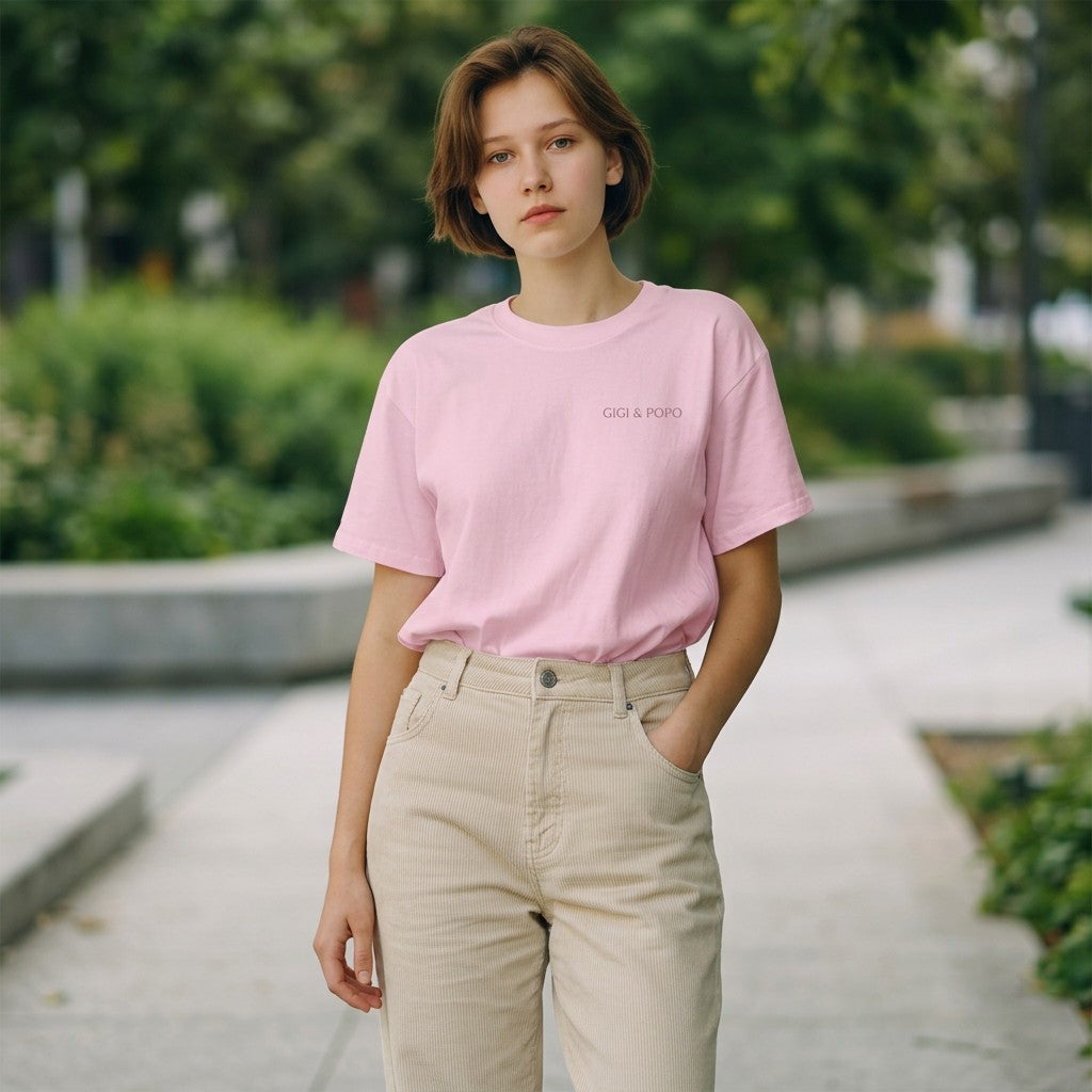 A woman wearing a GIGI & POPO light pink custom cotton t-shirt with a small logo, styled with beige corduroy pants.