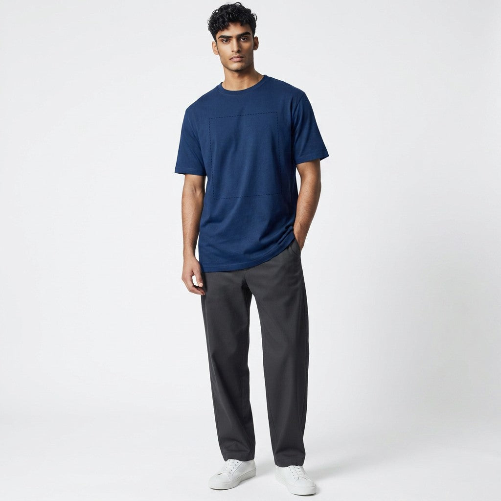 A man wearing a GIGI & POPO navy blue cotton crew neck t-shirt with a subtle square print design and grey trousers.