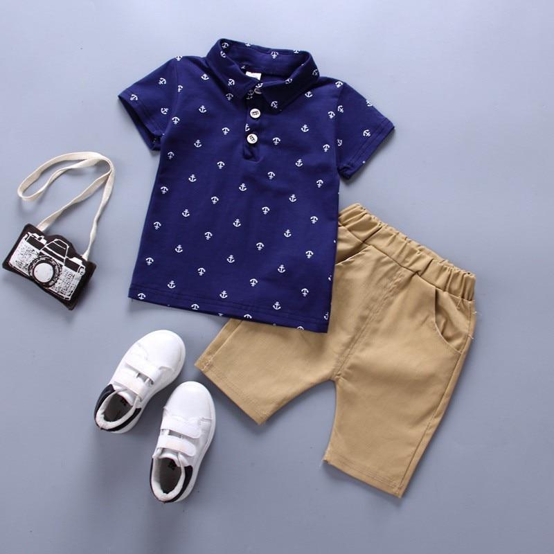 Toddler boy's polka dot shirt and shorts clothing set with camera and shoes.