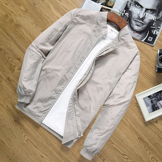 Men's nylon sun protection jacket in beige, laid flat with open front showing white inner fabric.